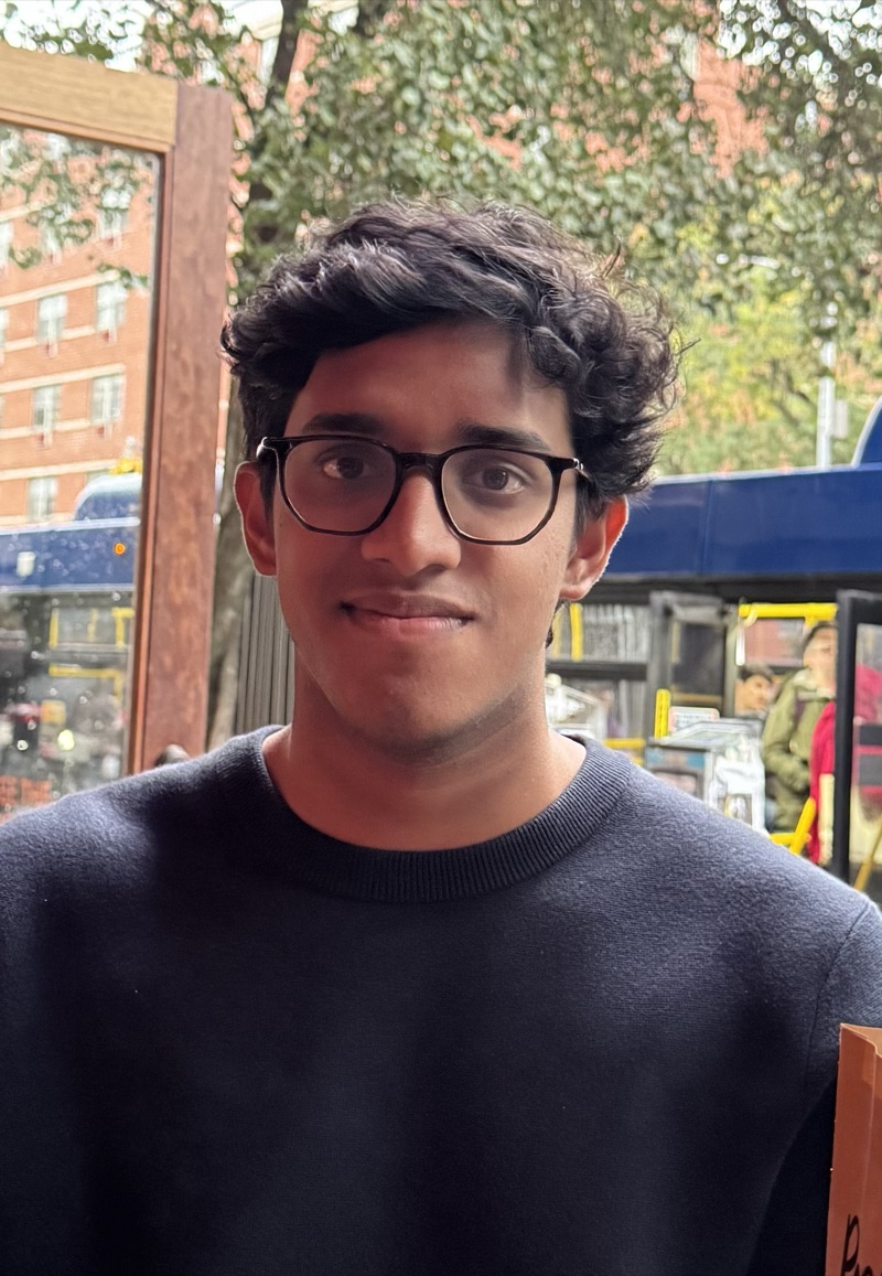 Shyam Soundararajan in glasses and a navy sweater on a city street